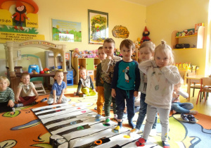 Dzieci grają w zespole na Kolorpiano, stawiają stopę na dany klawisz.